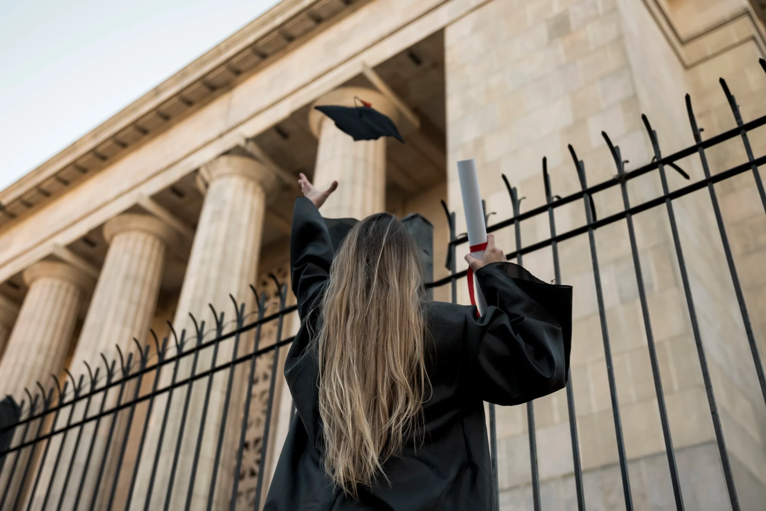 Étudiante de dos jette son chapeau